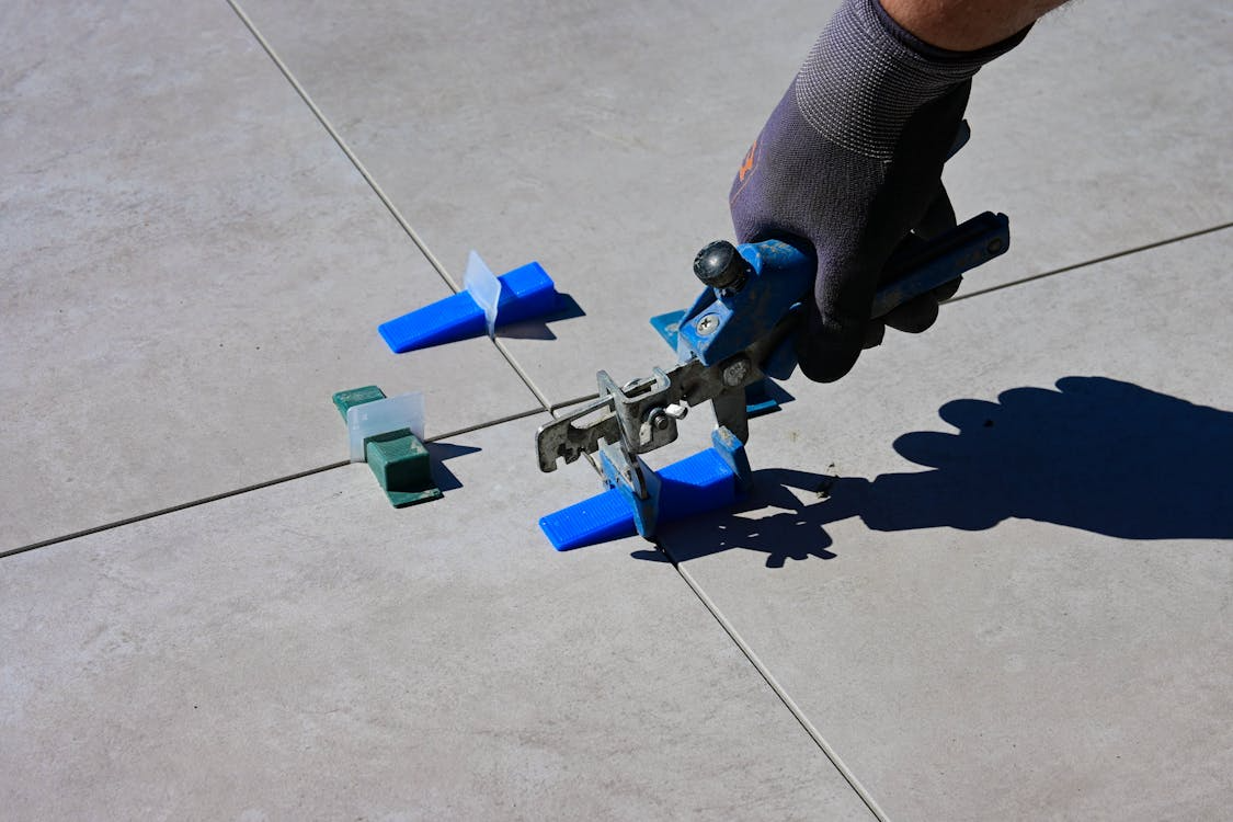 Technician aligning tile grout lines during preparation for grout color sealing service