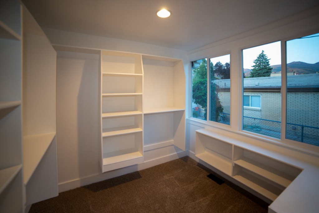 Built-in wall storage created through custom shelving installation for small spaces