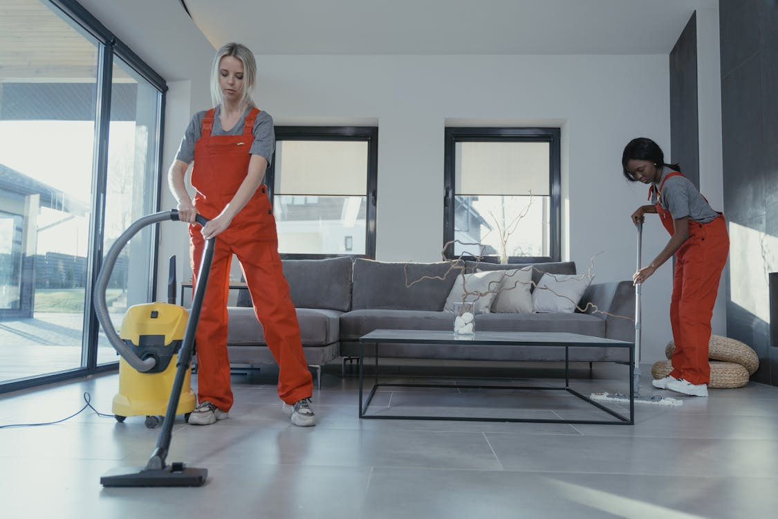 professional cleaners vacuuming during deep cleaning services before hosting events
